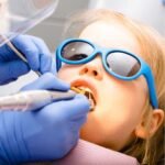 A neurodivergent-friendly pediatric dentist in San Diego using a "Tell-Show-Do" method with a young child on the Autism Spectrum.